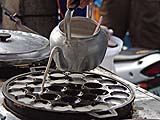 Pouring batter into sizzling hot khanom krok pans, Sukhmvit near Thonglor, Bangkok